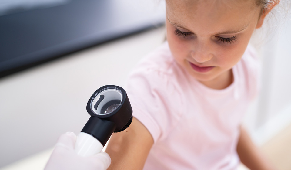 Dermatólogo examinando a un niño/a